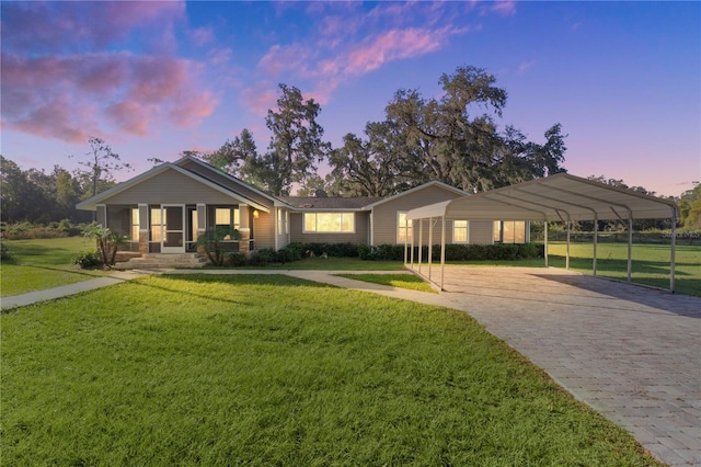 ranch-style home featuring a yard, a carport, and a porch