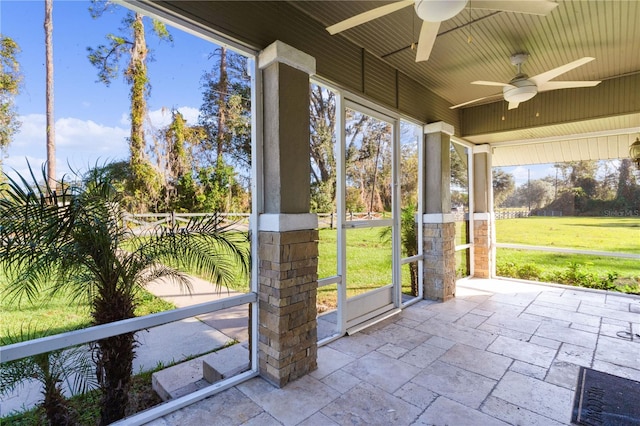 unfurnished sunroom with ceiling fan