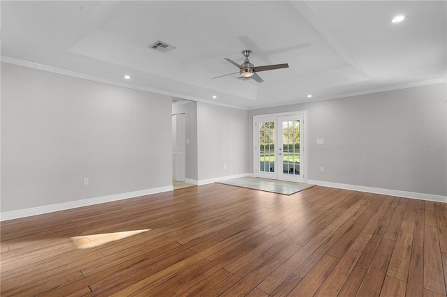 spare room with ornamental molding, ceiling fan, light hardwood / wood-style floors, and a raised ceiling