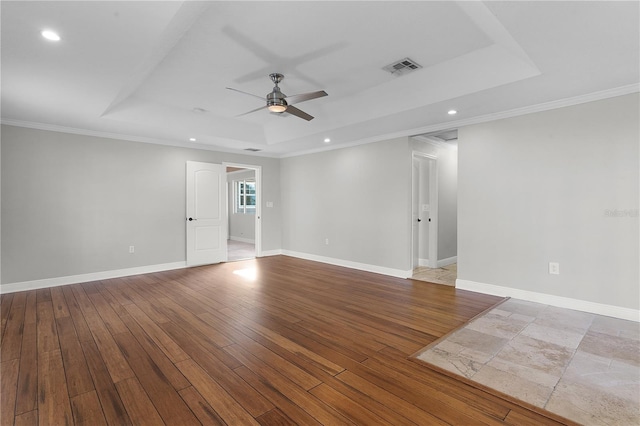 unfurnished room with ornamental molding, a tray ceiling, light hardwood / wood-style floors, and ceiling fan