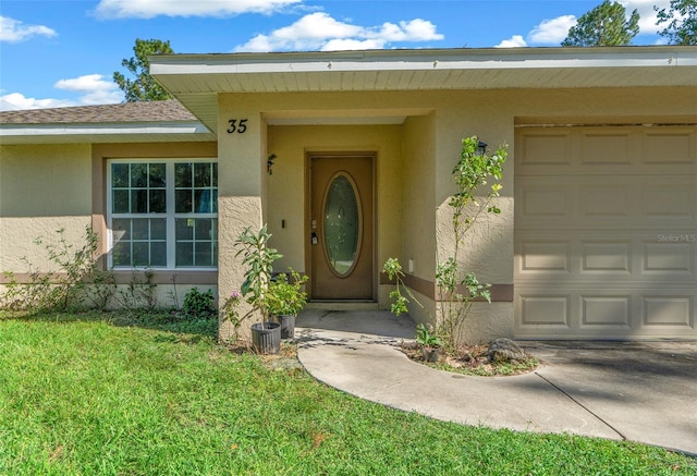 view of exterior entry with a yard and a garage