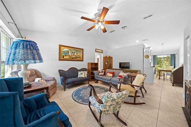 living room featuring lofted ceiling, ceiling fan with notable chandelier, and light tile patterned floors