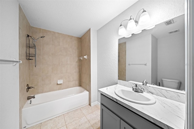 full bathroom with a textured ceiling, toilet, tile patterned floors, vanity, and tiled shower / bath combo