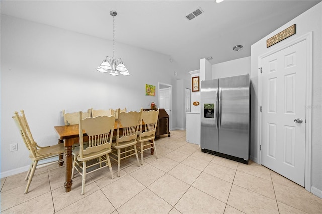 dining area featuring a notable chandelier, light tile patterned floors, and vaulted ceiling