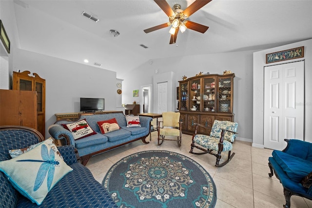 living room with ceiling fan, light tile patterned floors, and vaulted ceiling