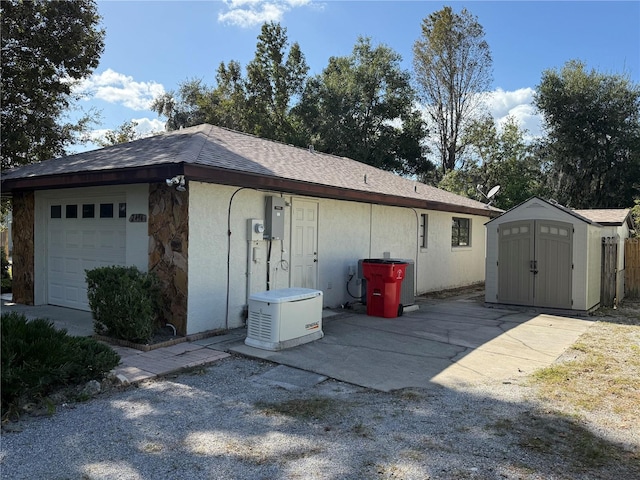 view of side of home featuring a storage unit and a garage