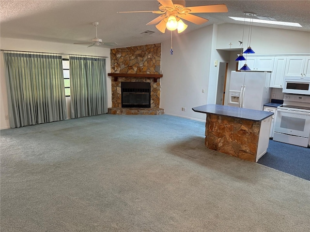 interior space featuring lofted ceiling, ceiling fan, a textured ceiling, carpet floors, and a fireplace