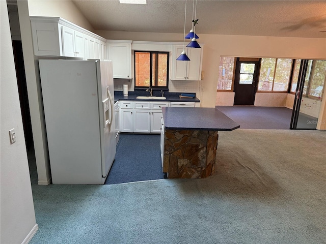 kitchen featuring decorative backsplash, hanging light fixtures, sink, white refrigerator with ice dispenser, and white cabinetry