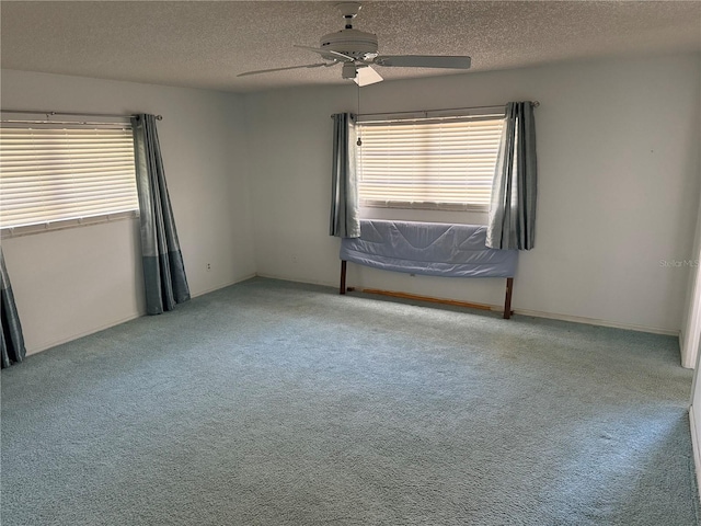 carpeted empty room with a textured ceiling and ceiling fan