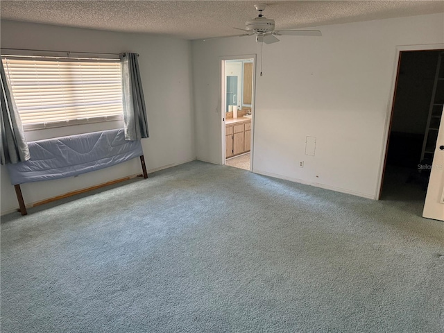 carpeted empty room featuring ceiling fan and a textured ceiling