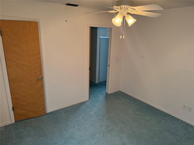 spare room featuring ceiling fan, carpet flooring, and a textured ceiling