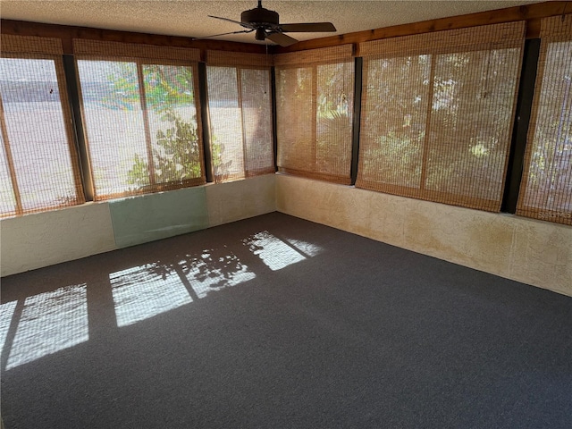 unfurnished sunroom with ceiling fan