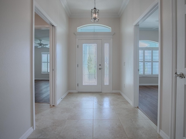 foyer entrance with a wealth of natural light, ornamental molding, and light wood-type flooring