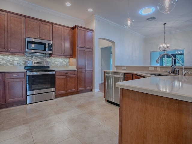 kitchen with appliances with stainless steel finishes, crown molding, sink, and hanging light fixtures