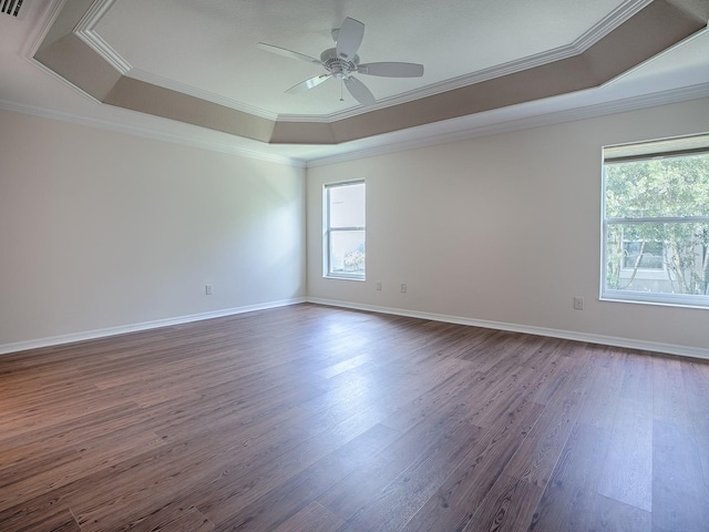 unfurnished room featuring crown molding, ceiling fan, hardwood / wood-style flooring, and a raised ceiling