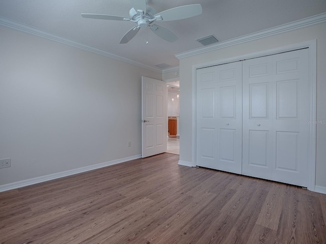 unfurnished bedroom featuring ornamental molding, a closet, light hardwood / wood-style floors, and ceiling fan