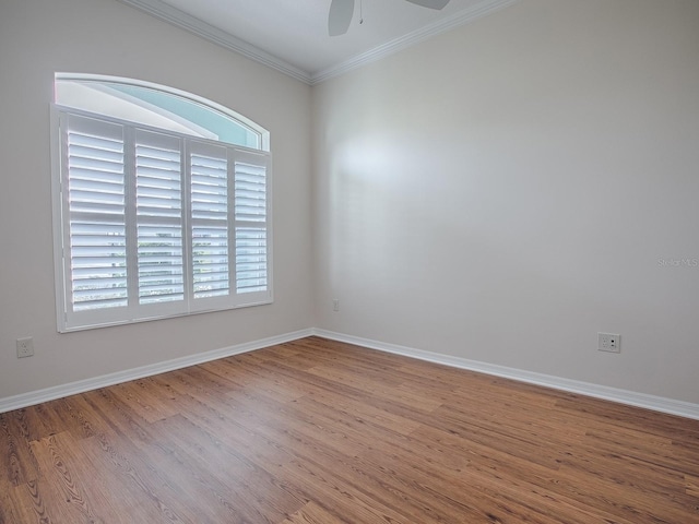 empty room featuring ornamental molding, wood-type flooring, and ceiling fan