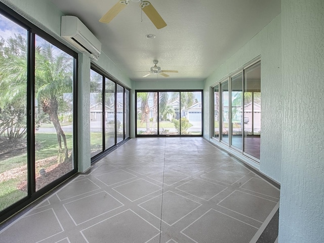 unfurnished sunroom with ceiling fan, a healthy amount of sunlight, and a wall mounted air conditioner