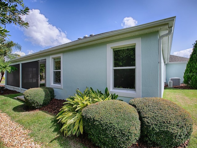 view of home's exterior featuring a lawn and a sunroom