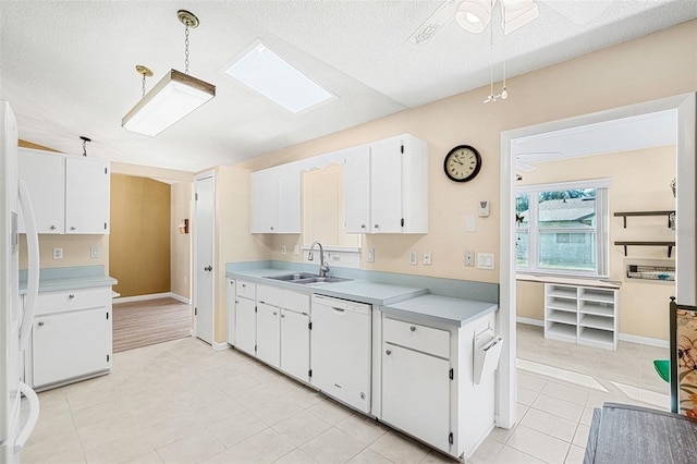 kitchen with dishwasher, sink, hanging light fixtures, ceiling fan, and white cabinets