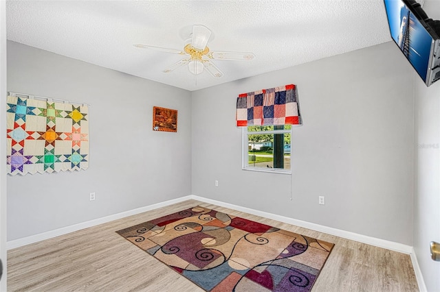 spare room with hardwood / wood-style floors, a textured ceiling, and ceiling fan