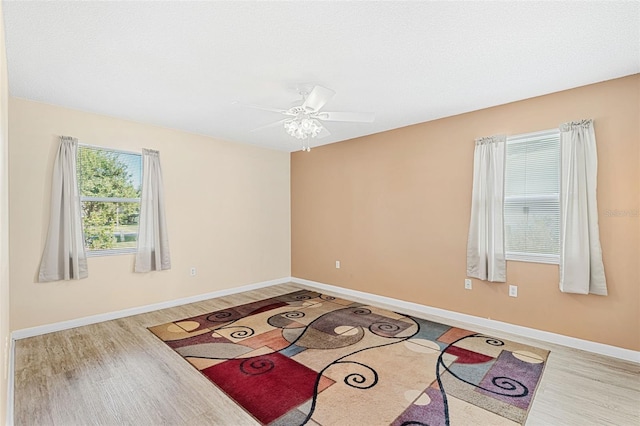 empty room with light hardwood / wood-style flooring and ceiling fan