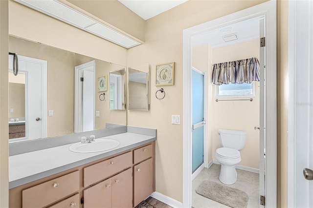 bathroom featuring vanity, toilet, and walk in shower