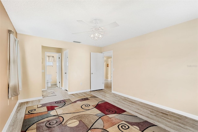 spare room with light hardwood / wood-style floors, a textured ceiling, and ceiling fan