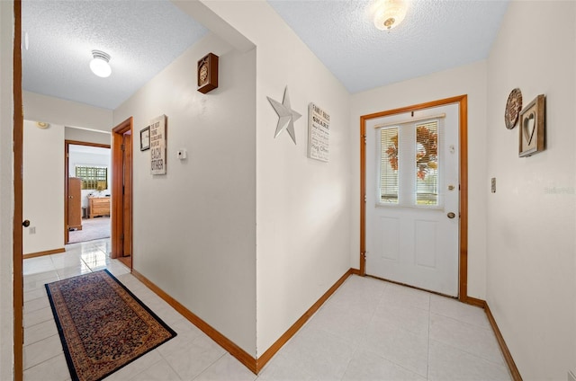 interior space featuring a textured ceiling and light tile patterned floors