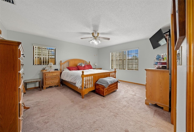 carpeted bedroom featuring a textured ceiling and ceiling fan