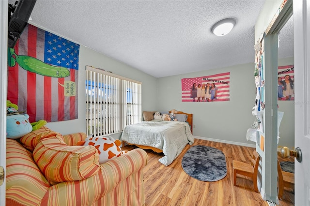 bedroom with a textured ceiling and hardwood / wood-style floors