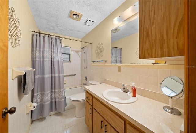 full bathroom with a textured ceiling, shower / bath combination with curtain, toilet, tile patterned floors, and vanity