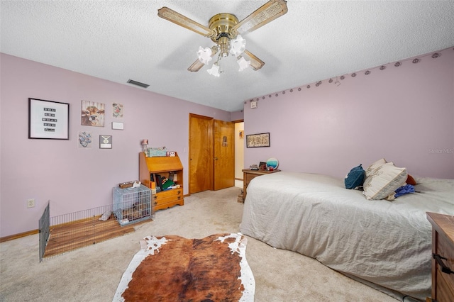 bedroom with a textured ceiling, carpet floors, and ceiling fan