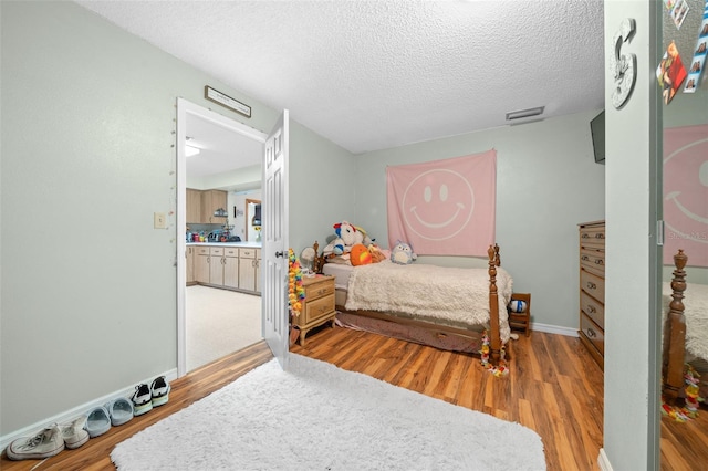 bedroom with hardwood / wood-style flooring and a textured ceiling