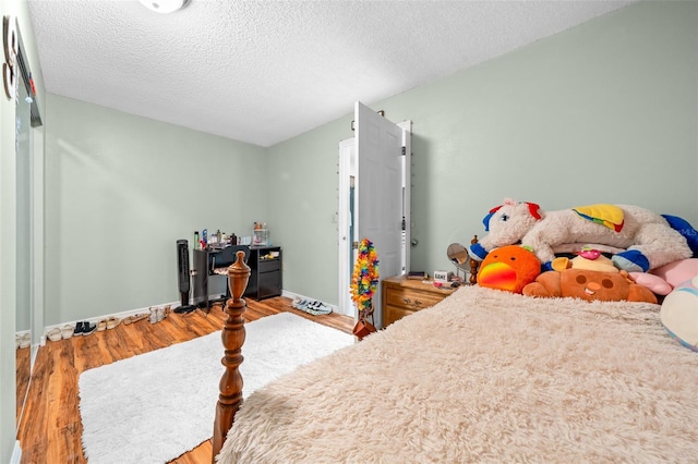 bedroom with hardwood / wood-style floors and a textured ceiling