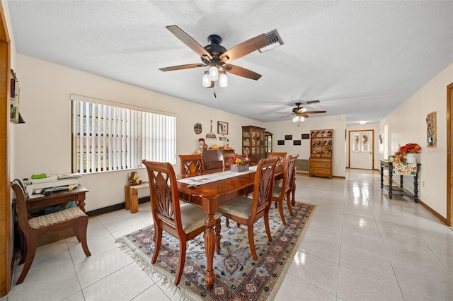 dining space with light tile patterned flooring, a textured ceiling, and ceiling fan