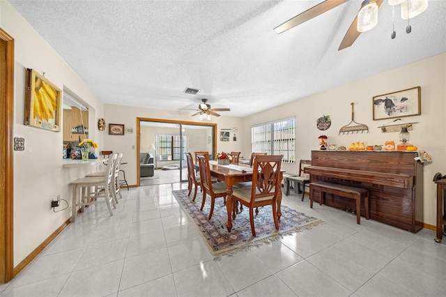 dining area featuring ceiling fan, a textured ceiling, and light tile patterned floors