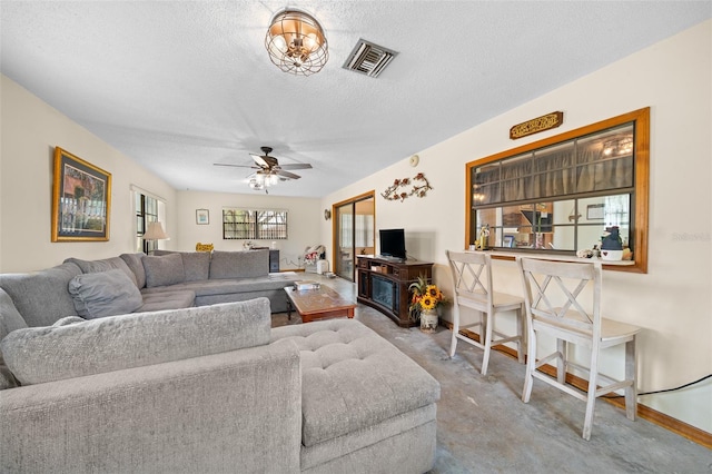 living room featuring a textured ceiling, light colored carpet, and ceiling fan