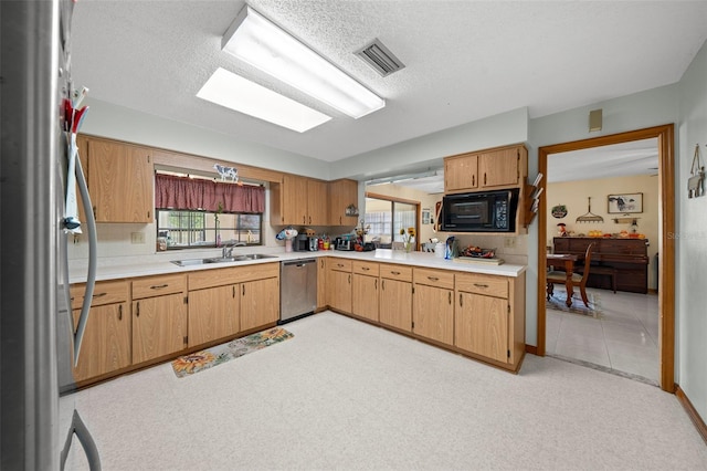 kitchen with stainless steel appliances, a textured ceiling, and sink