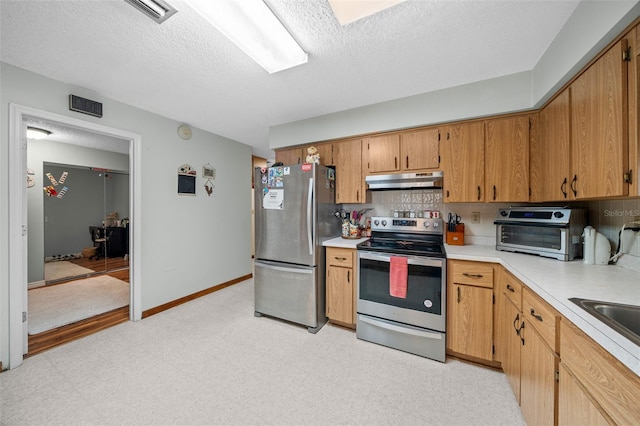 kitchen with tasteful backsplash, appliances with stainless steel finishes, and a textured ceiling