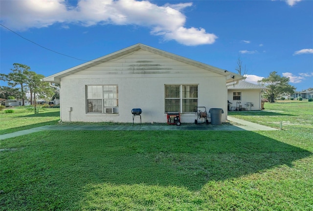 rear view of property featuring a yard and cooling unit