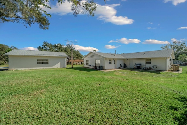 rear view of house with a patio and a lawn