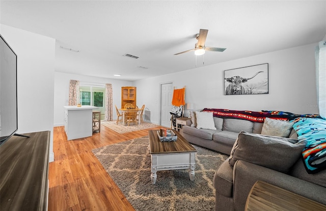 living room featuring light hardwood / wood-style floors and ceiling fan