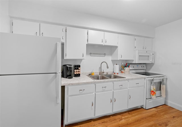 kitchen with white appliances, light hardwood / wood-style flooring, white cabinetry, and sink