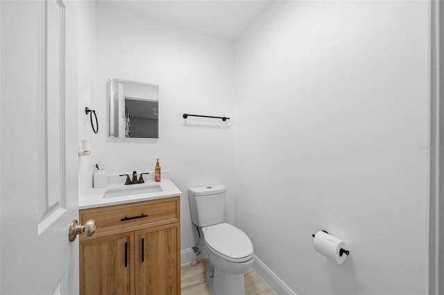 bathroom with vanity, toilet, and wood-type flooring