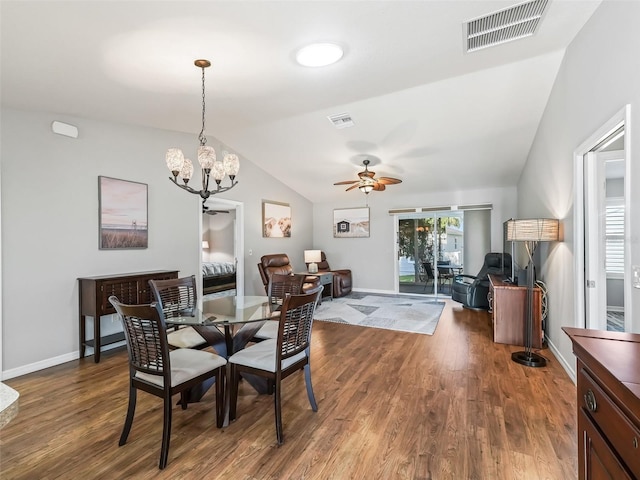 dining space featuring visible vents, ceiling fan with notable chandelier, lofted ceiling, and wood finished floors