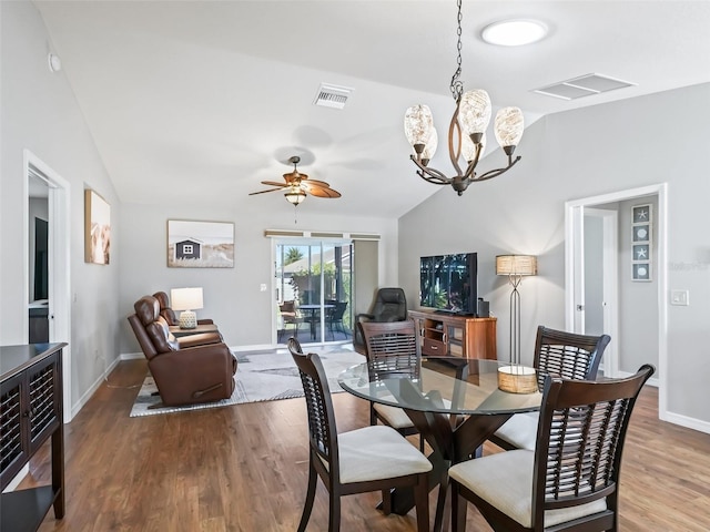 dining room with lofted ceiling, hardwood / wood-style flooring, and ceiling fan with notable chandelier