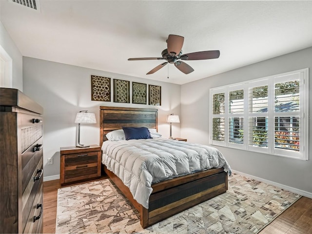 bedroom featuring baseboards, a ceiling fan, light wood-type flooring, and visible vents