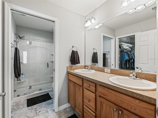 full bath with double vanity, a sink, visible vents, and a shower stall