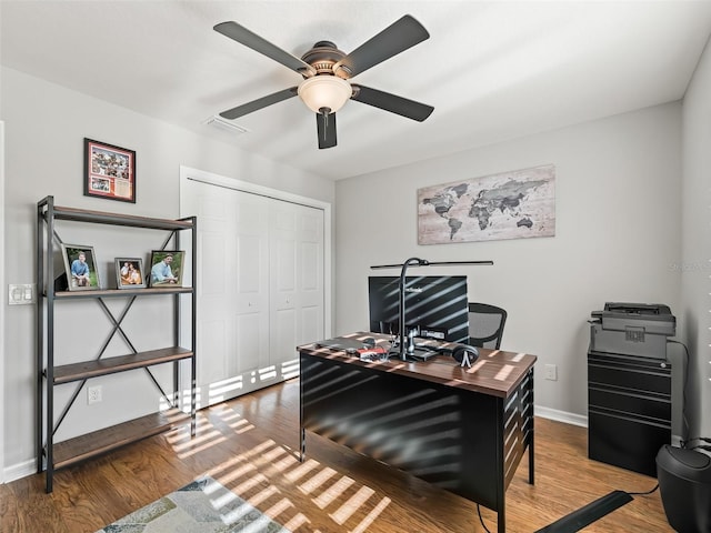 office area with baseboards, ceiling fan, and wood finished floors